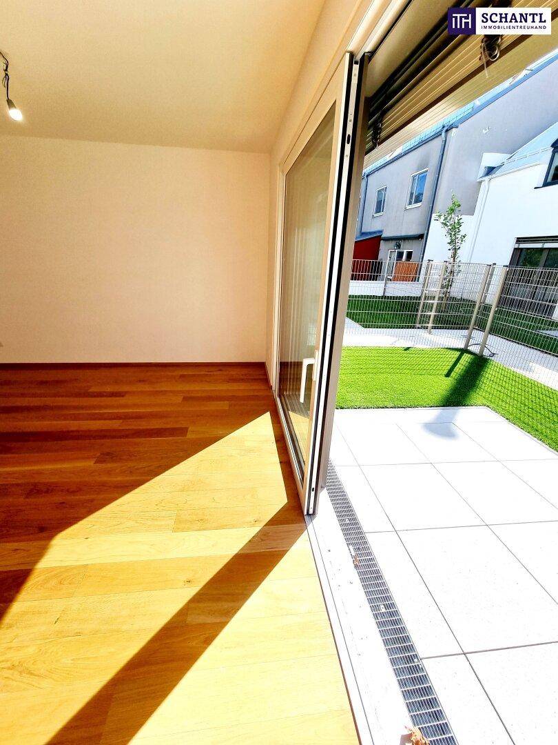 Lichtdurchfluteter Wohnbereich mit Holzboden und direktem Zugang zur sonnigen Terrasse.