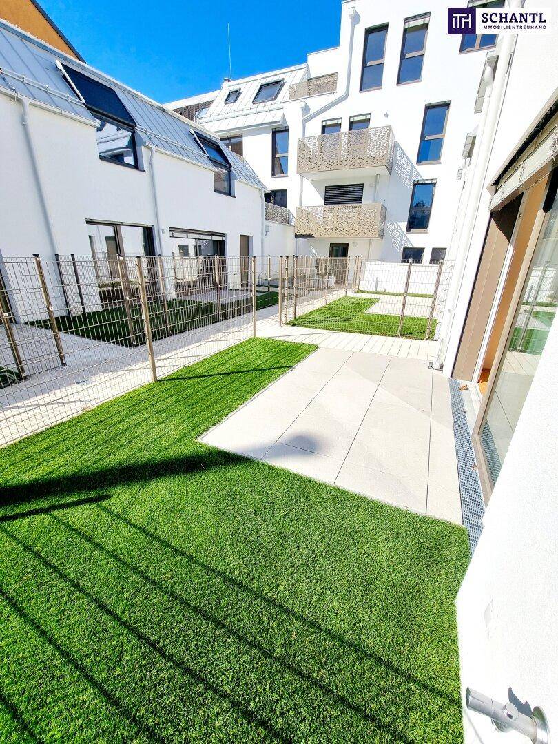 Gepflegte Gärten und Terrassenbereiche einer modernen Wohnanlage unter blauem Himmel.