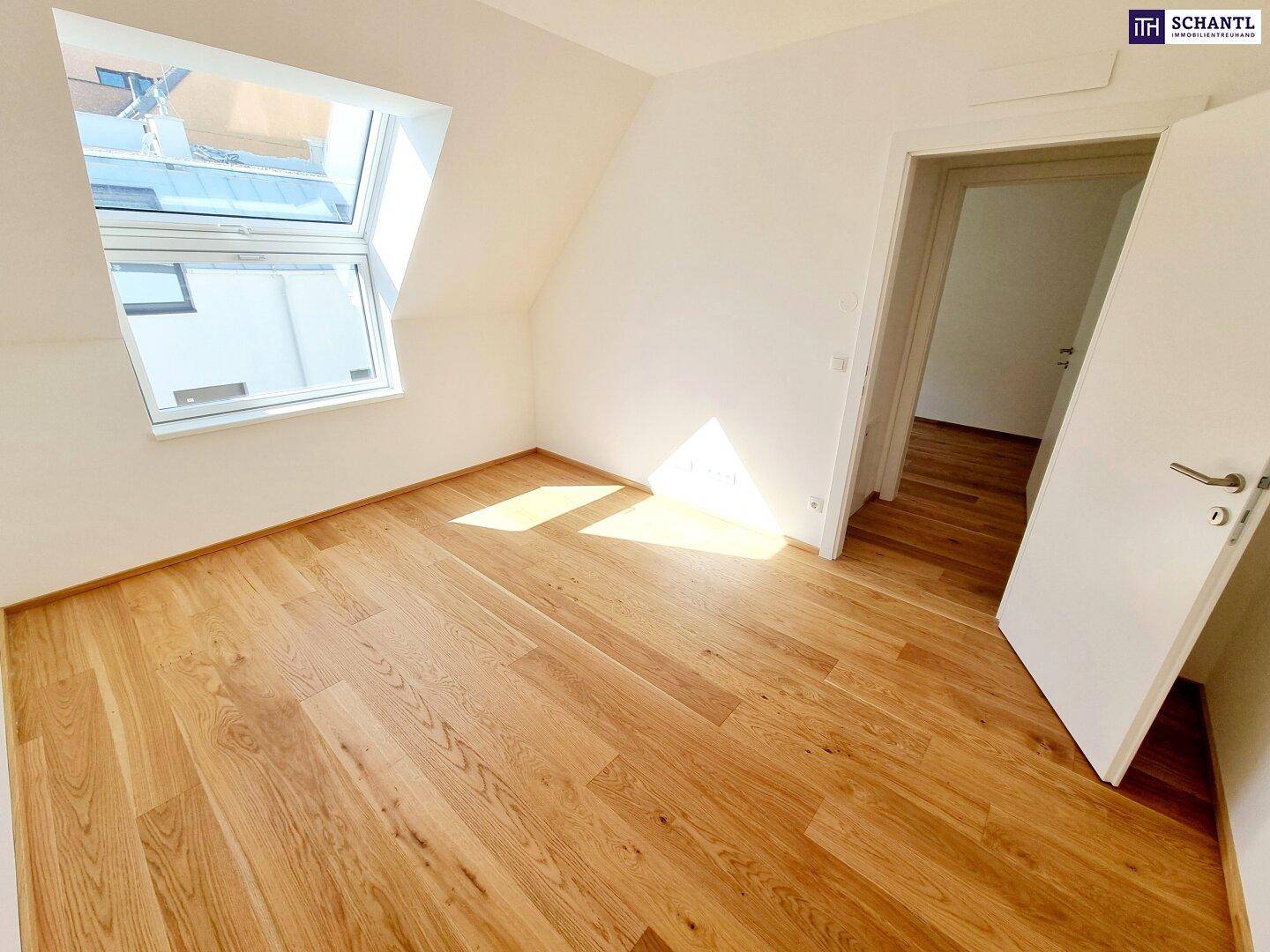 Schlafzimmer im Dachgeschoss mit Holzboden, Dachfenster und viel natürlichem Licht.
