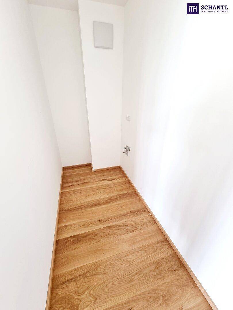 Kleiner Abstellraum mit Parkettboden und Anschlüssen, ideal für Waschmaschine oder Lagerung.