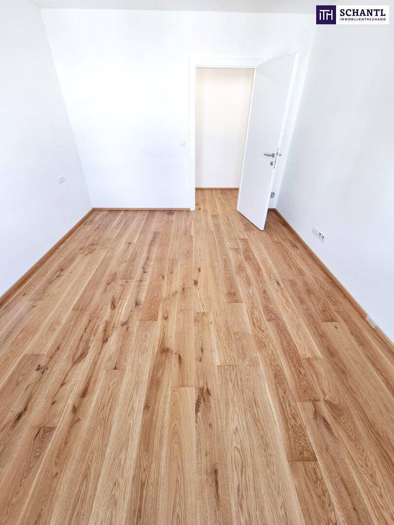 Unmöblierter Raum mit Parkettboden und weiß gestrichenen Wänden, ideal als Schlafzimmer.