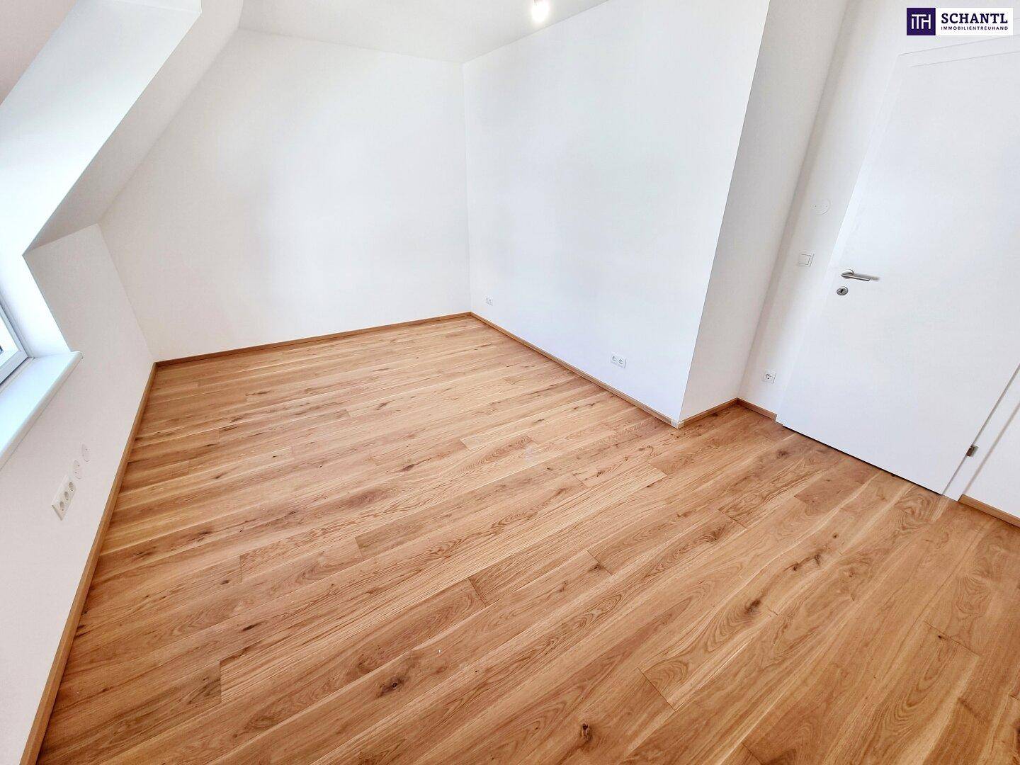 Helles Schlafzimmer mit Parkettboden und weißen Wänden, bereit zur individuellen Gestaltung.