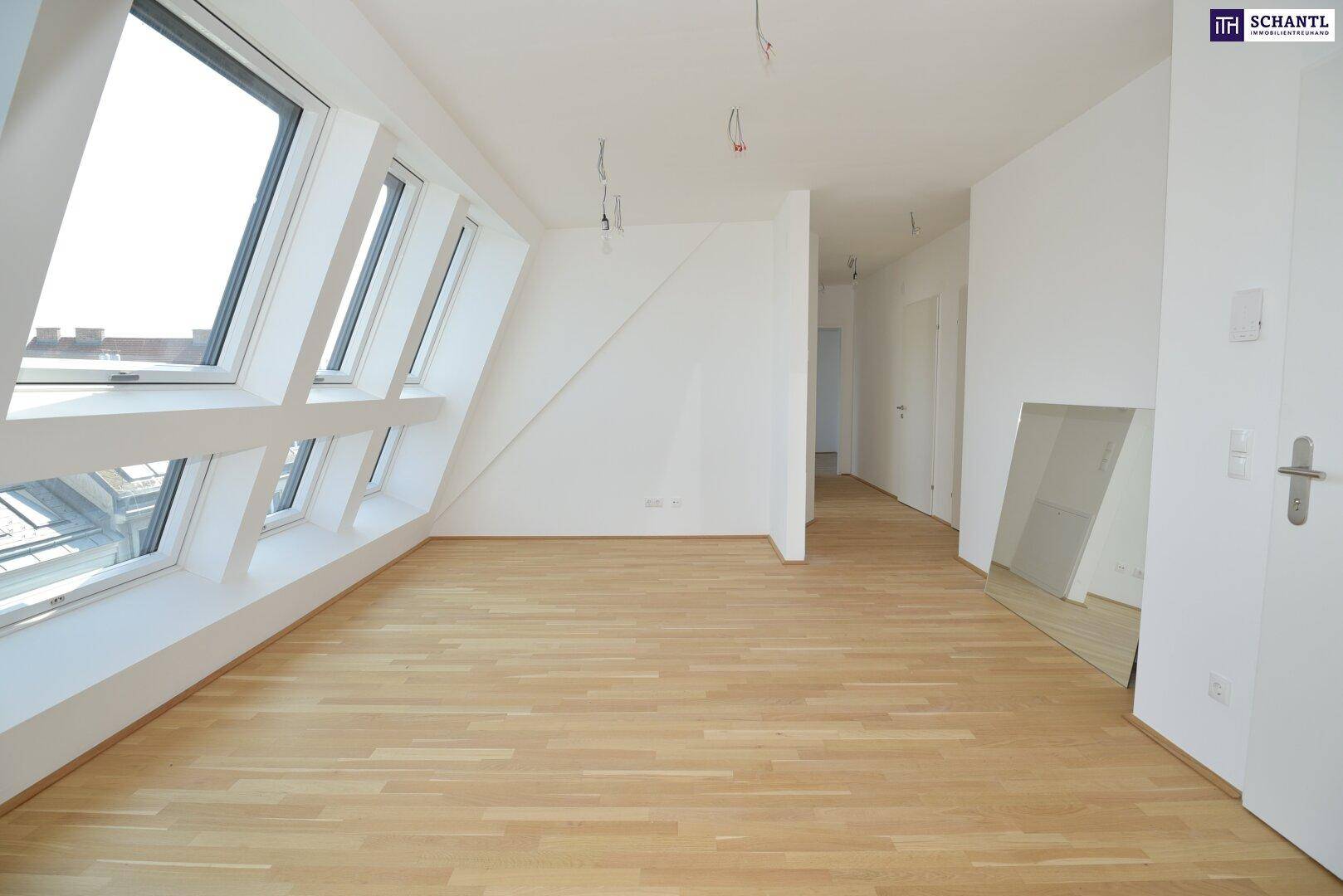 Geräumiger, heller Wohnraum mit vielen Fenstern und hellem Holzparkett, ideal für individuelle Gestaltung.