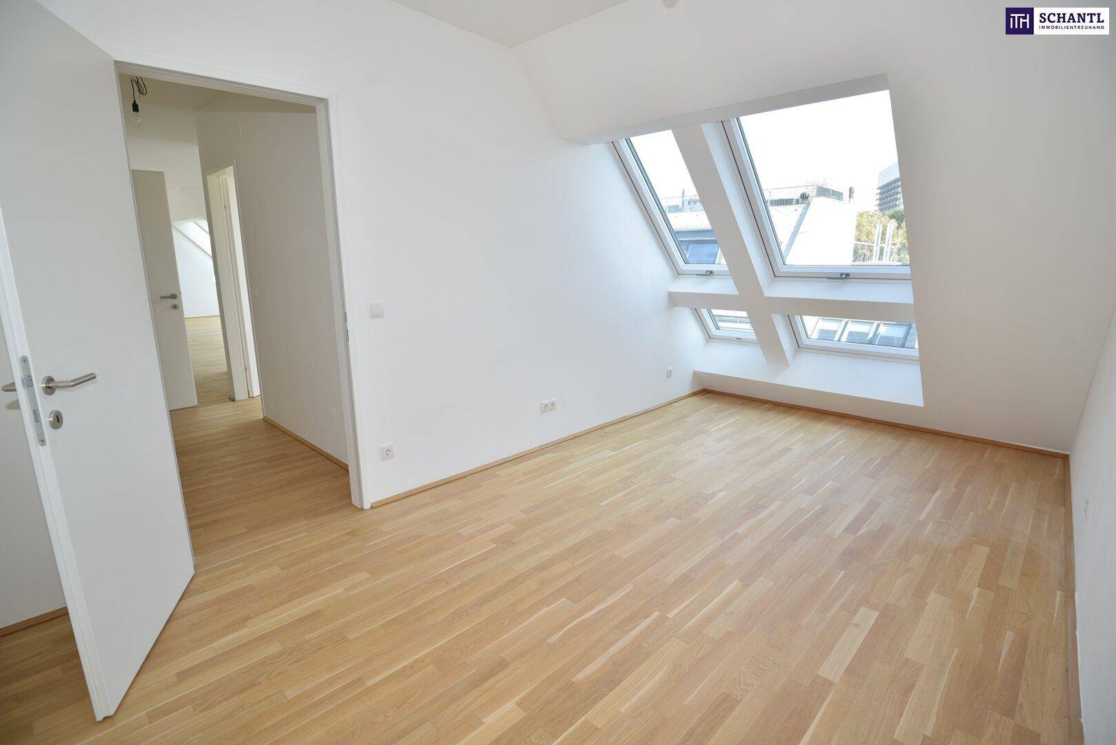 Heller Raum mit Holzparkett und schrägen Dachfenstern, ideal als Schlaf- oder Arbeitszimmer.