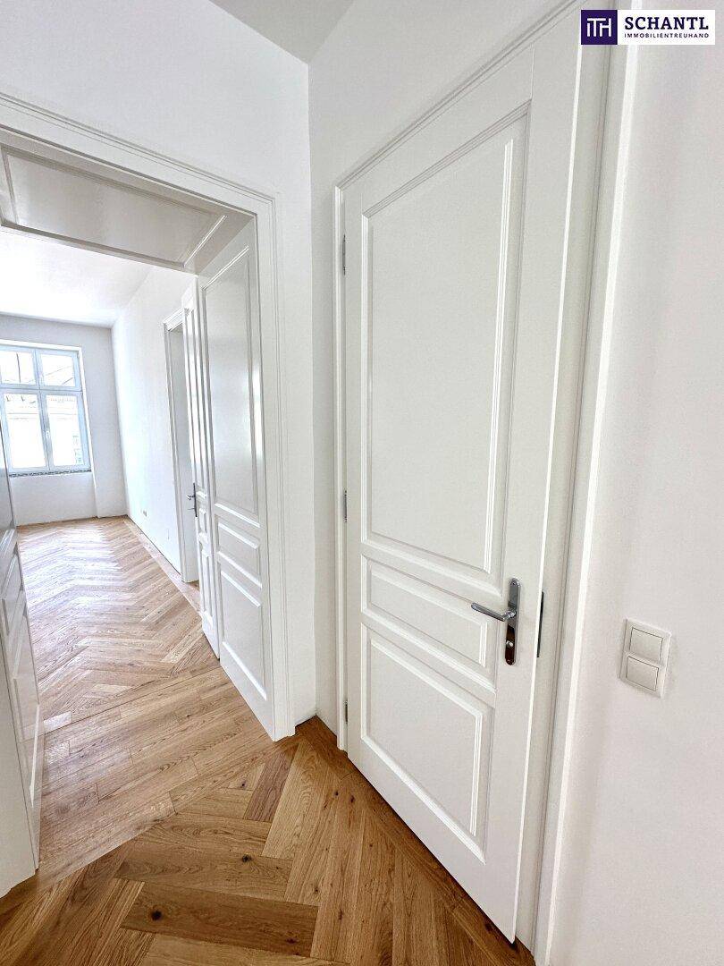 Eleganter Flur mit Fischgrätparkett und klassischen weißen Türen, die den Altbaucharme unterstreichen.