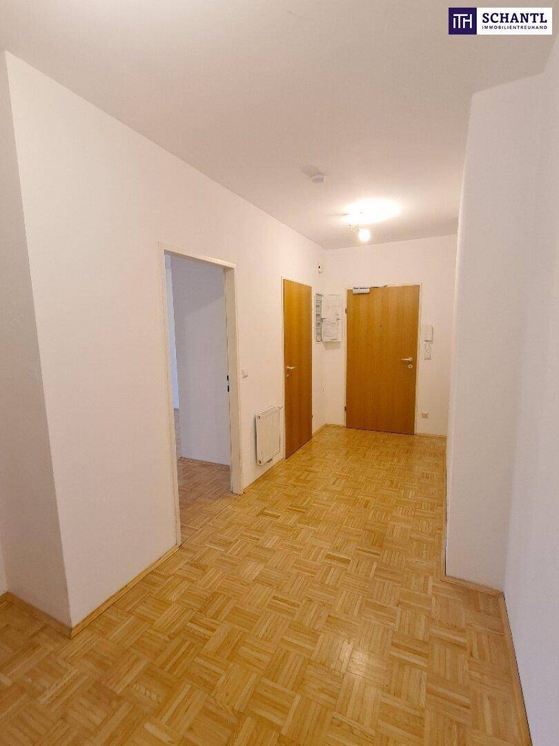 Langer Flur mit Parkettboden und Türen, der verschiedene Bereiche der Wohnung verbindet.