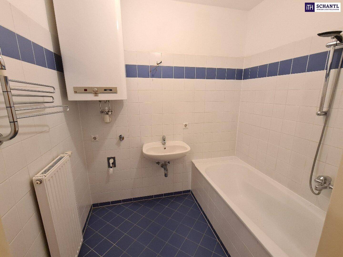 Badezimmer mit Badewanne, Waschbecken und Fliesen in Weiß und Blau.