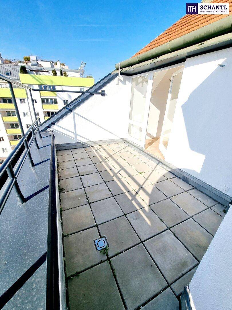 Kleiner Balkon mit Fliesenboden und Blick auf die umliegenden Gebäude unter blauem Himmel.