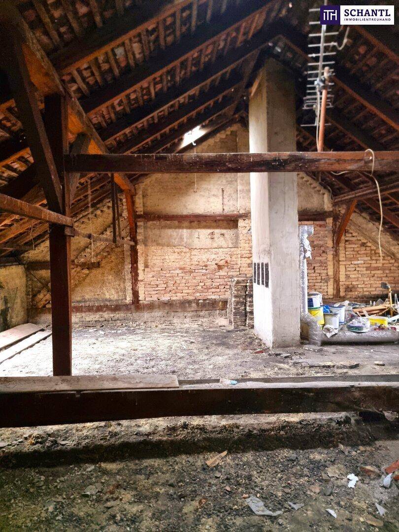Rohdachboden mit sichtbaren Holzbalken und Ziegelwänden, bietet viel Potenzial für Ausbau.