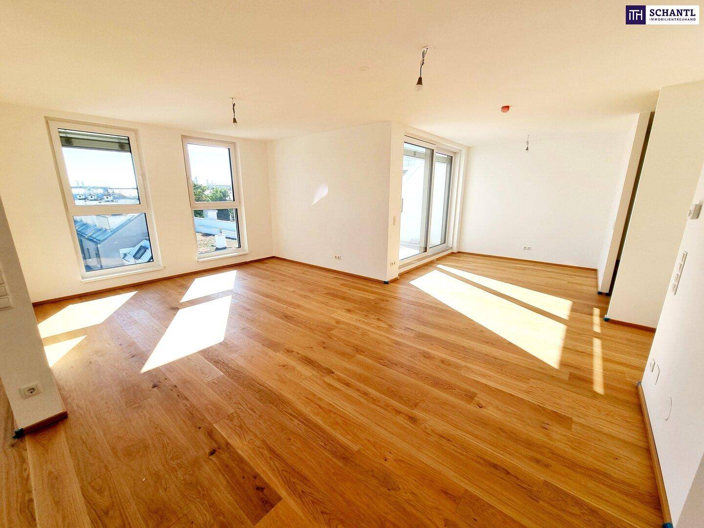 Geräumiger, heller Raum mit Parkettboden und mehreren Fenstern, bietet viel Tageslicht.