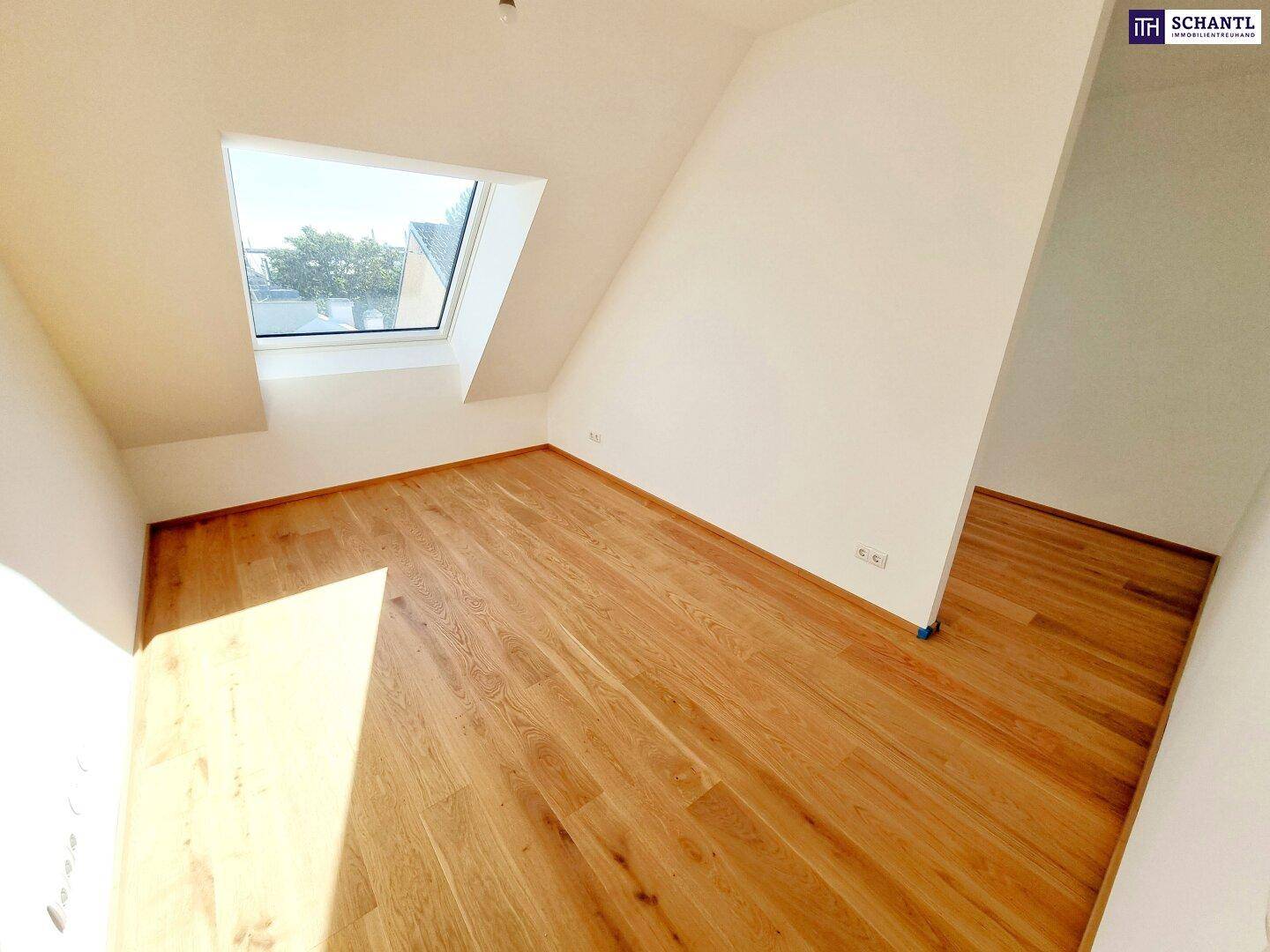 Helles Zimmer im Dachgeschoss mit Holzboden und Dachfenster, bietet viel Tageslicht.