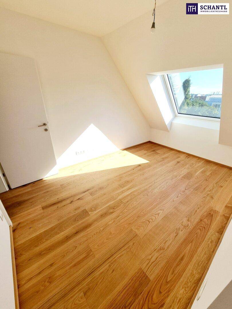 Helles Dachzimmer mit Holzboden und großem Dachfenster, bietet eine angenehme Atmosphäre.