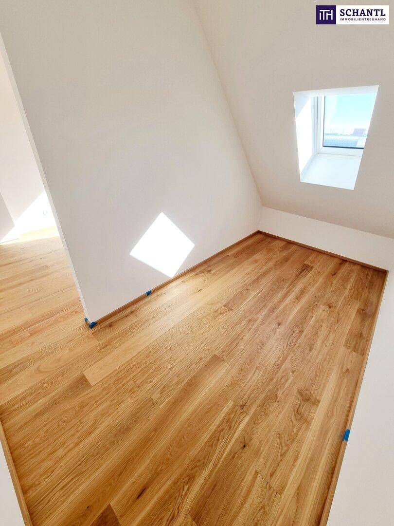 Gemütliches Zimmer im Dachgeschoss mit Holzboden und Dachfenster, ideal für ein Kinderzimmer.