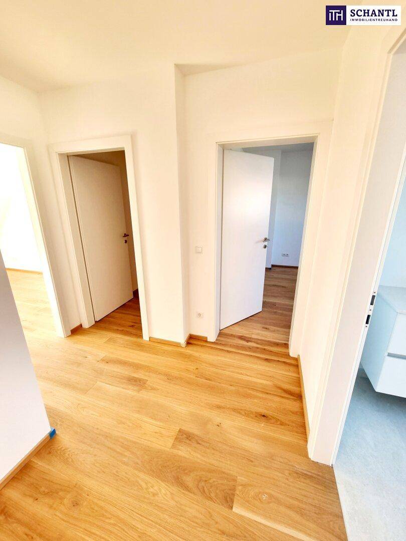 Heller Flur mit Holzboden und Zugang zu mehreren Zimmern, modern und einladend.