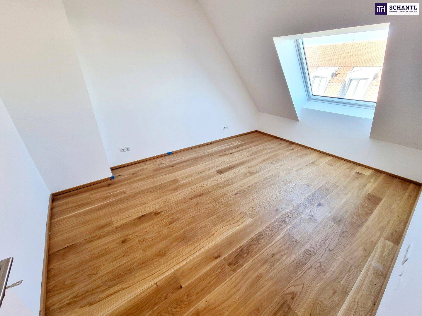 Dachgeschosszimmer mit Holzboden und Dachfenster, bietet viel Potenzial für individuelle Gestaltung.