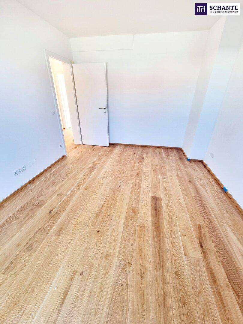 Helles Zimmer mit Holzboden und weiß gestrichenen Wänden, bereit zur individuellen Einrichtung.