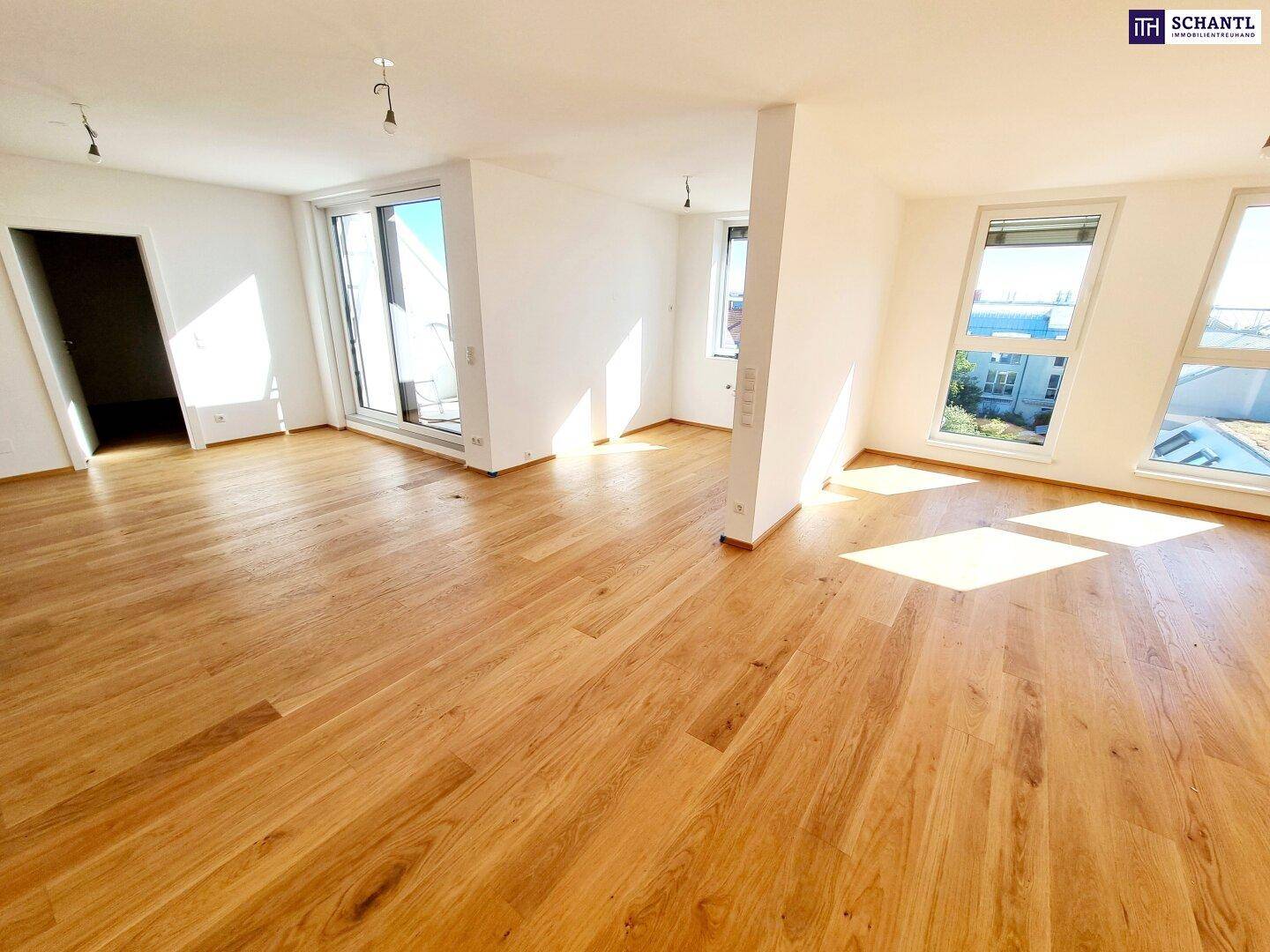 Großzügiger, heller Raum mit Parkettboden und großen Fenstern, ideal für offenes Wohnen.