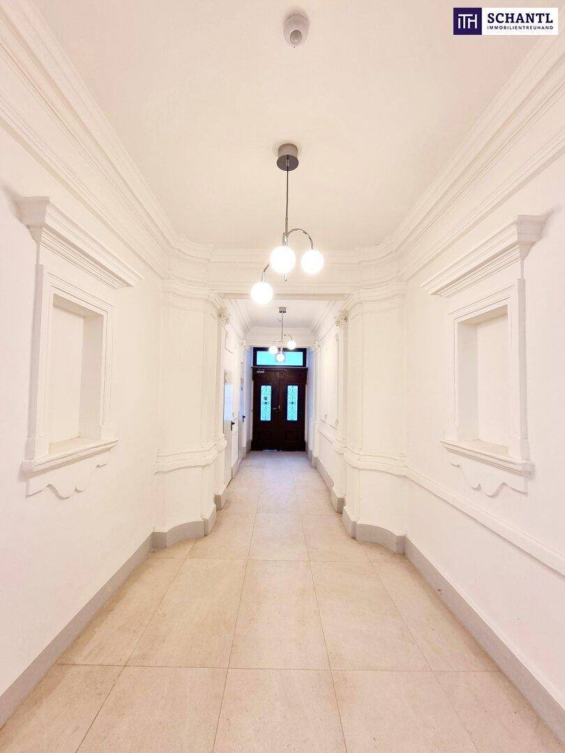 Eleganter Eingangsbereich mit Stuckdecken und Fliesenboden, der zum Haupttreppenhaus und den Wohnungen führt.