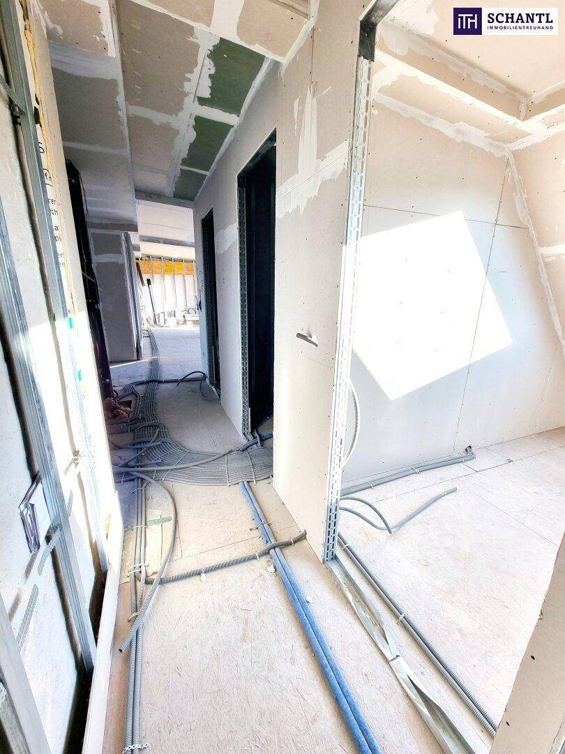 Innenraum im Rohbau mit Trockenbauwänden und sichtbaren Installationen, bereit für den Ausbau.