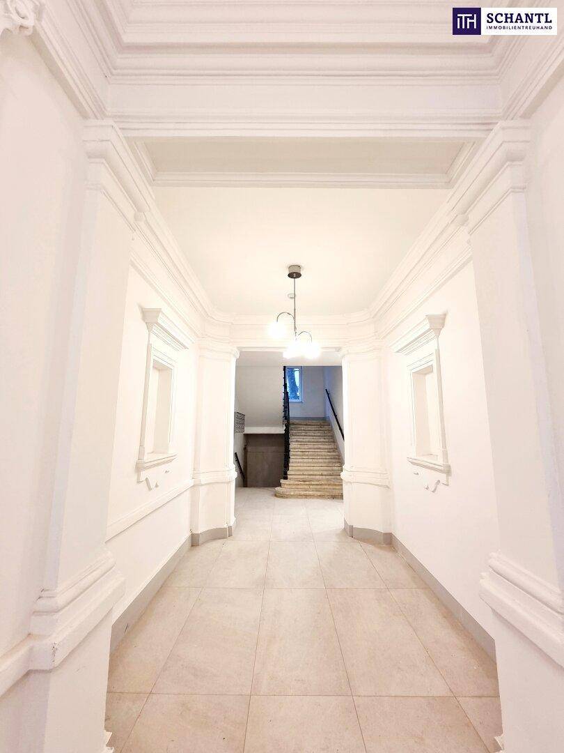 Heller Flur mit eleganten Stuckverzierungen an Wänden und Decke, der den Zugang zum Treppenhaus bietet.