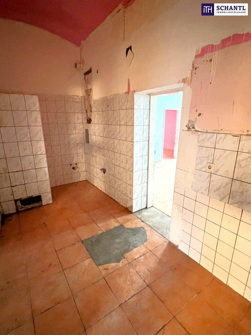 Raum in Renovierung mit gefliesten Wänden und Terrakottaboden, bereit für den Umbau.