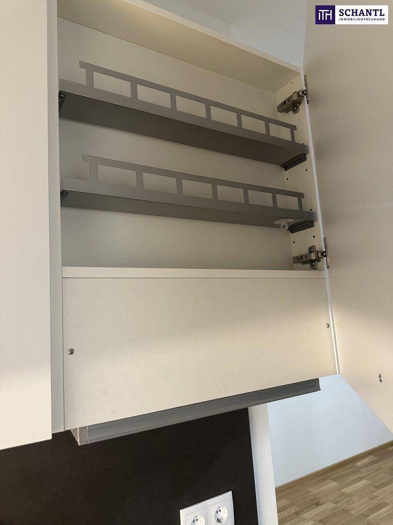 Offener Küchenschrank mit praktischen Auszügen für Gewürze und Vorräte.
