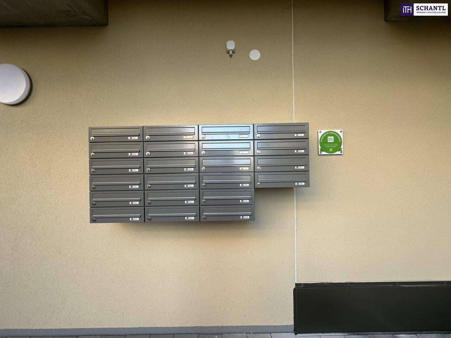 Reihe von modernen Briefkästen an der Fassade eines Apartmentgebäudes.
