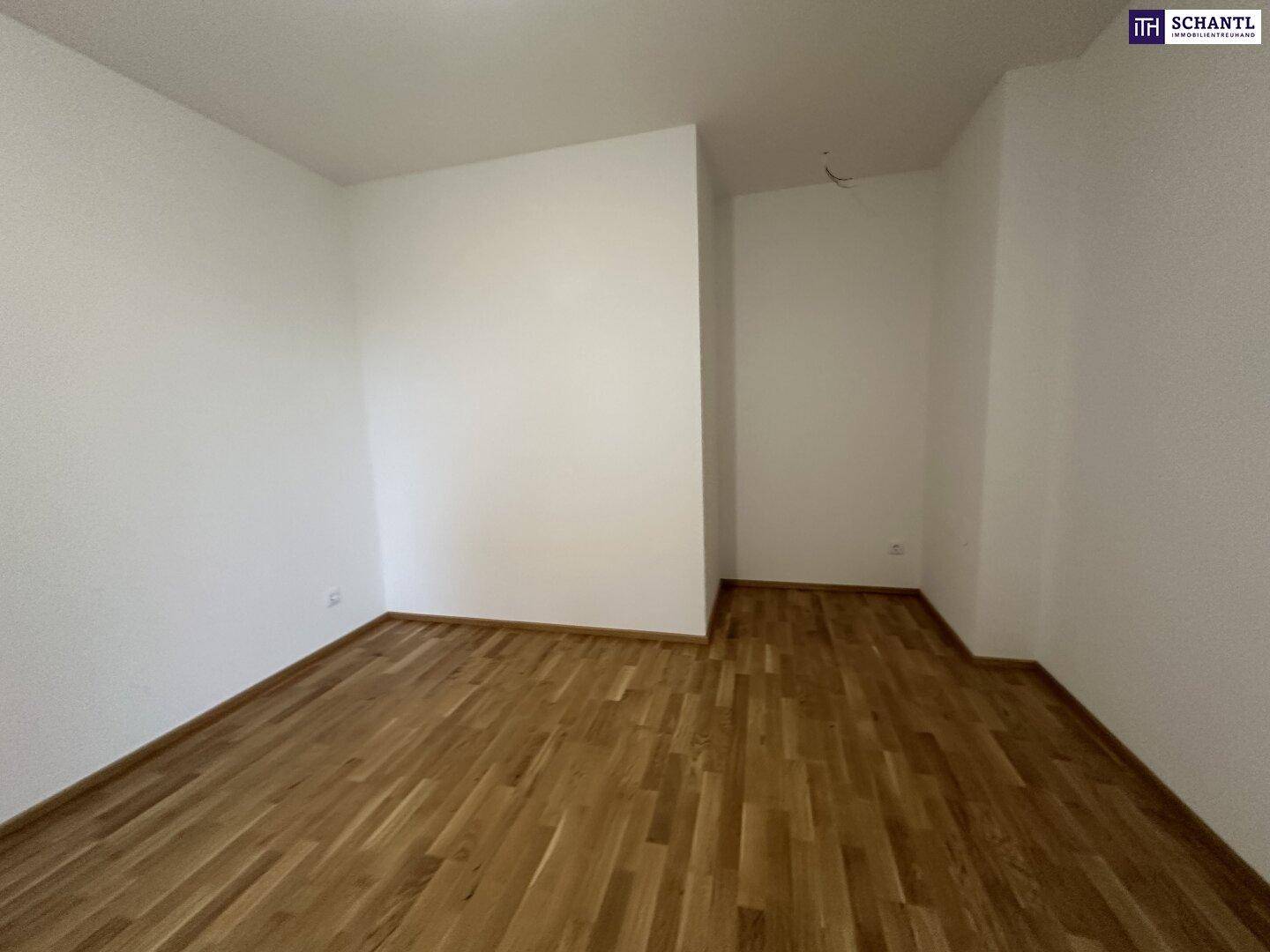 Leeres Zimmer mit hellem Holzparkettboden und frisch gestrichenen weißen Wänden.