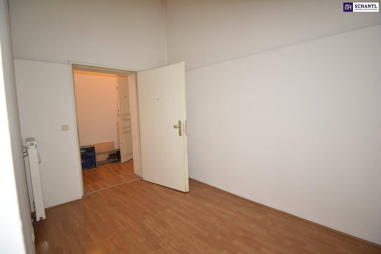 Leerer Raum mit Laminatboden und weiß gestrichenen Wänden, bereit zur individuellen Gestaltung.