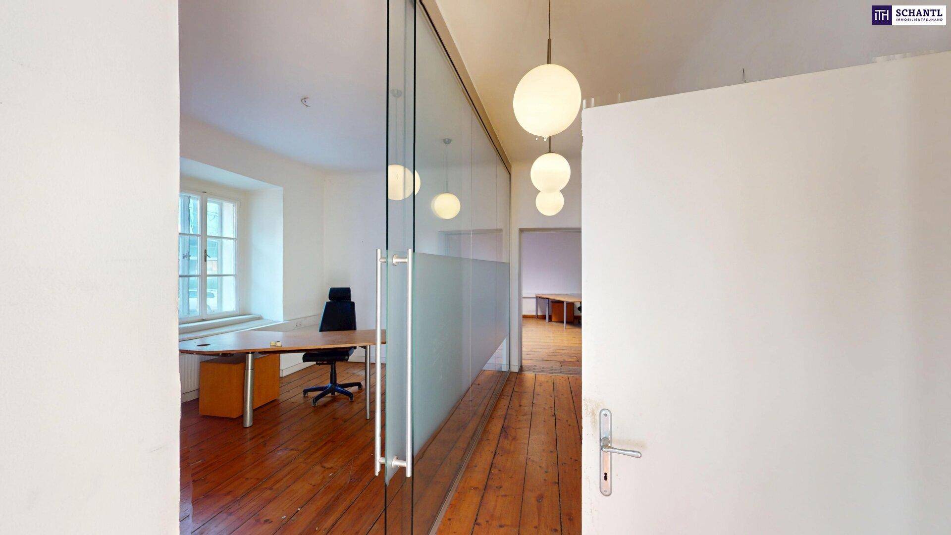 Heller Flur mit Glaselementen und Holzboden, der den Blick in ein Büro freigibt und modern wirkt.