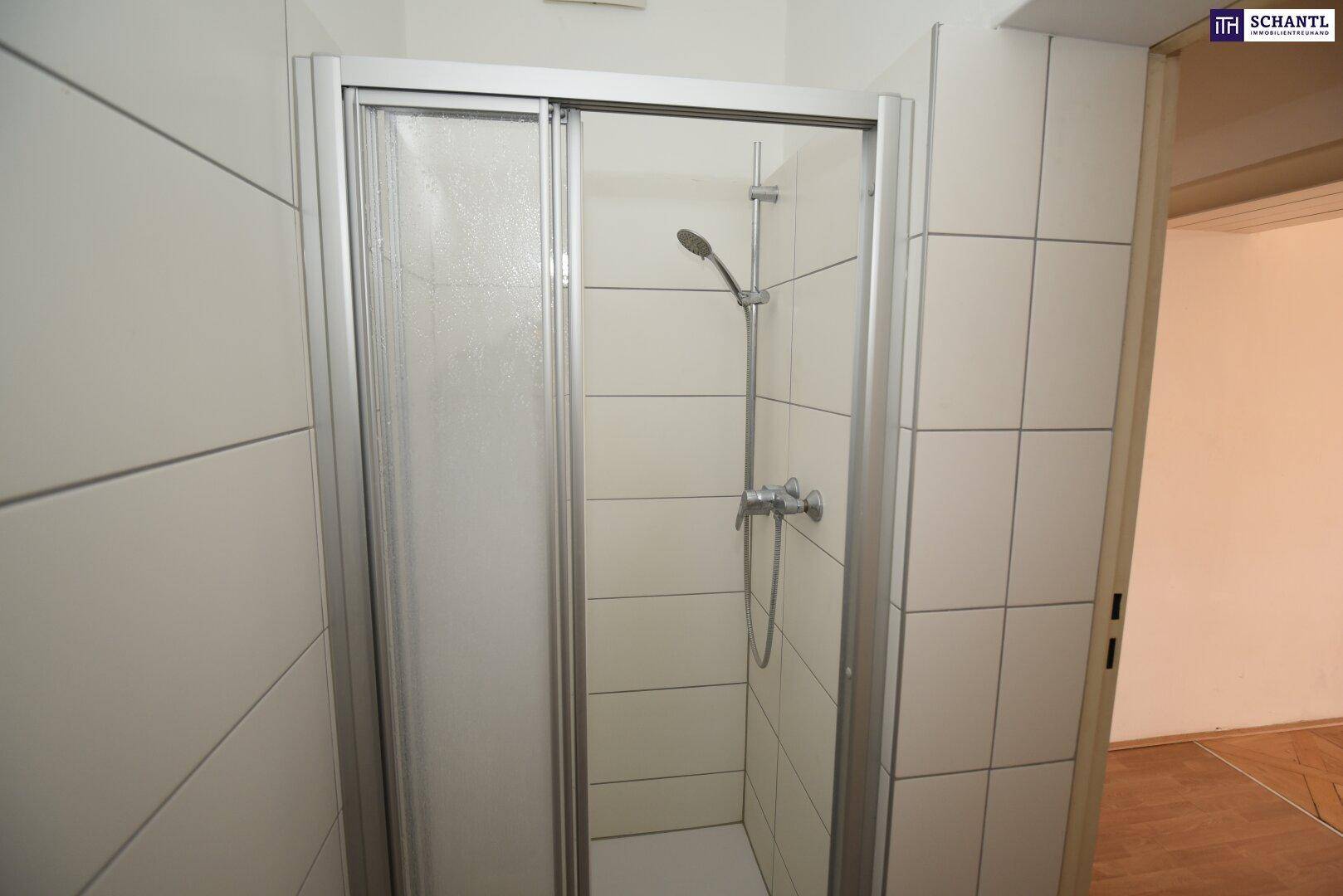 Funktionale Dusche mit Glasabtrennung und weißen Fliesen, praktisch und pflegeleicht.
