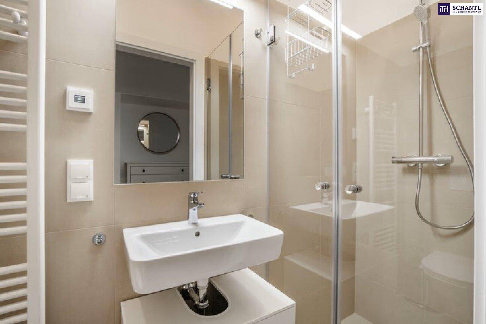 Modernes Badezimmer mit Duschkabine, Waschbecken und beheiztem Handtuchhalter.
