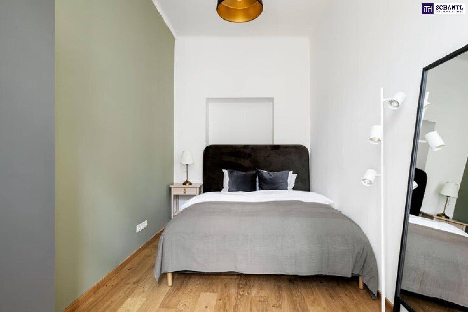 Gemütliches Schlafzimmer mit Holzboden, einem Doppelbett und einer modernen Stehlampe.