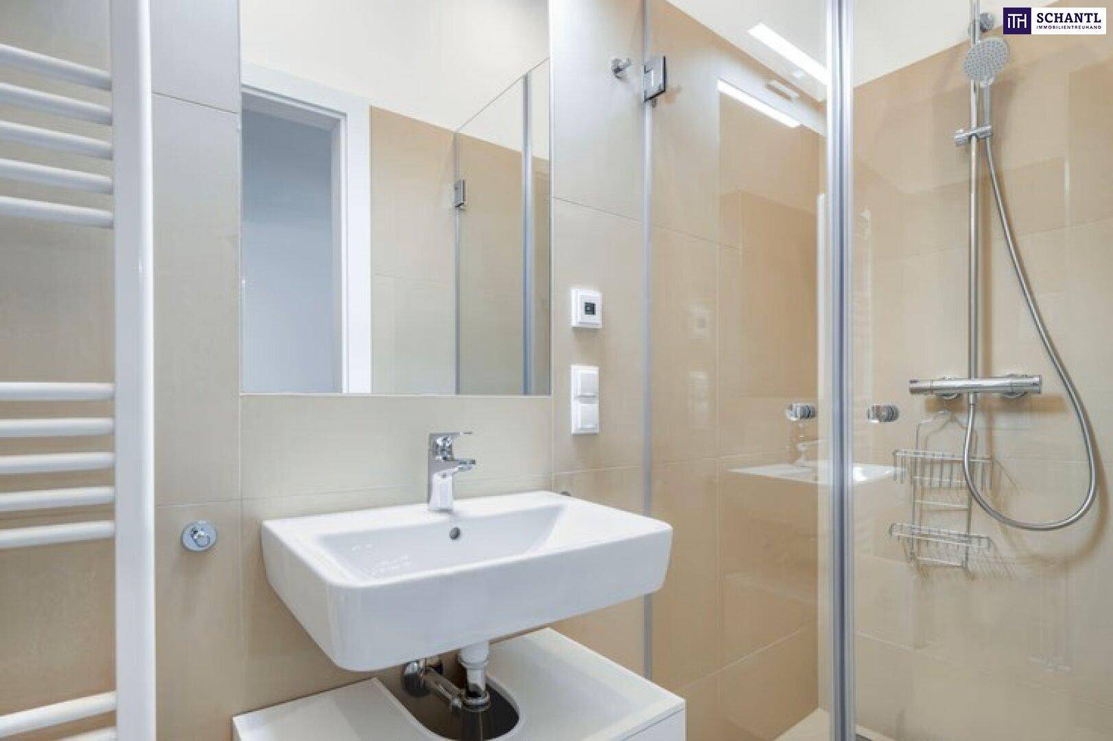 Modernes Badezimmer mit beigefarbenen Fliesen, Duschkabine und beheiztem Handtuchhalter.