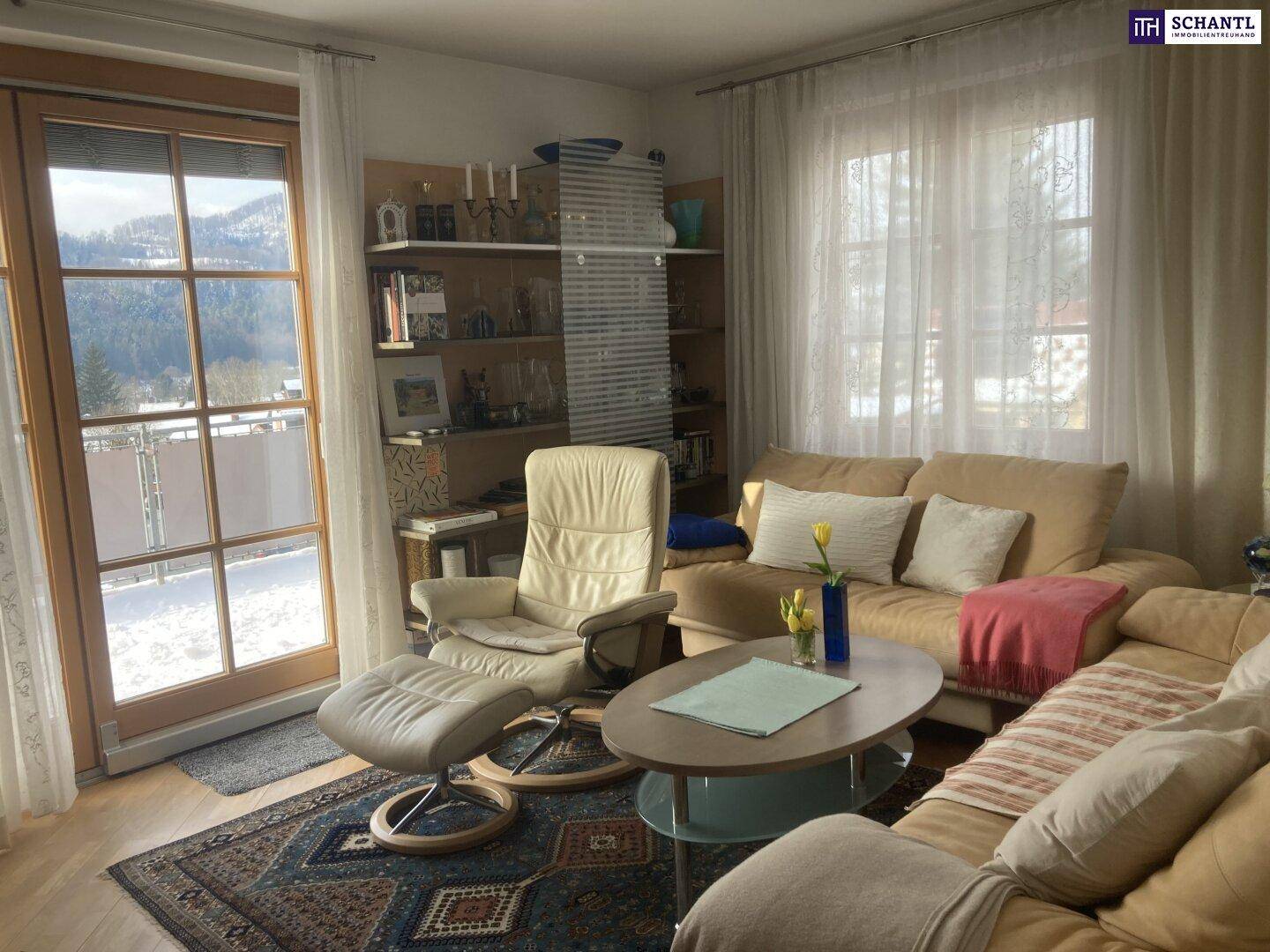Gemütliches Wohnzimmer mit großem Fenster und Zugang zu einem Balkon, bietet viel natürliches Licht.
