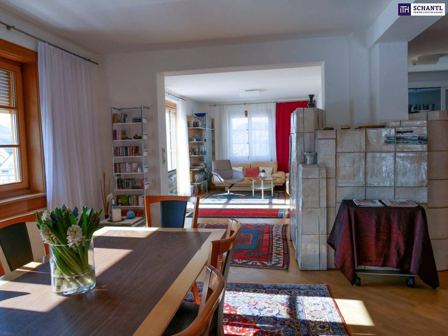 Offener Wohn-Essbereich mit Esstisch und gemütlichem Wohnzimmer, verbunden durch einen Durchgang.