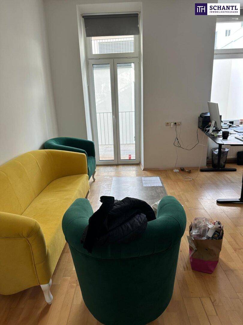 Wohnzimmer mit farbenfrohen Möbeln, Parkettboden und Zugang zu einem französischen Balkon.
