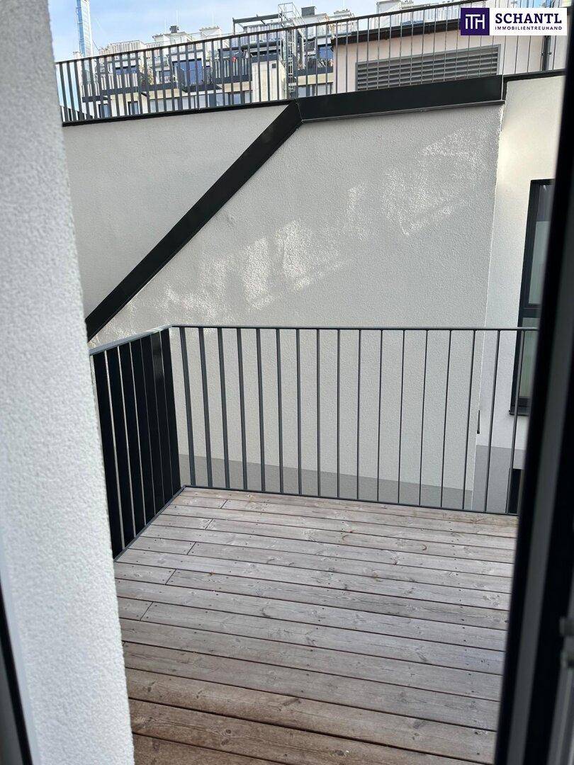 Balkon mit Holzdielenboden und schwarzem Metallgeländer, ideal für entspannte Stunden im Freien.