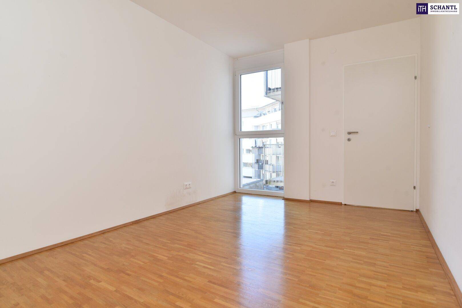 Helles Schlafzimmer mit Parkettboden und großem Fenster, bereit zur individuellen Gestaltung.