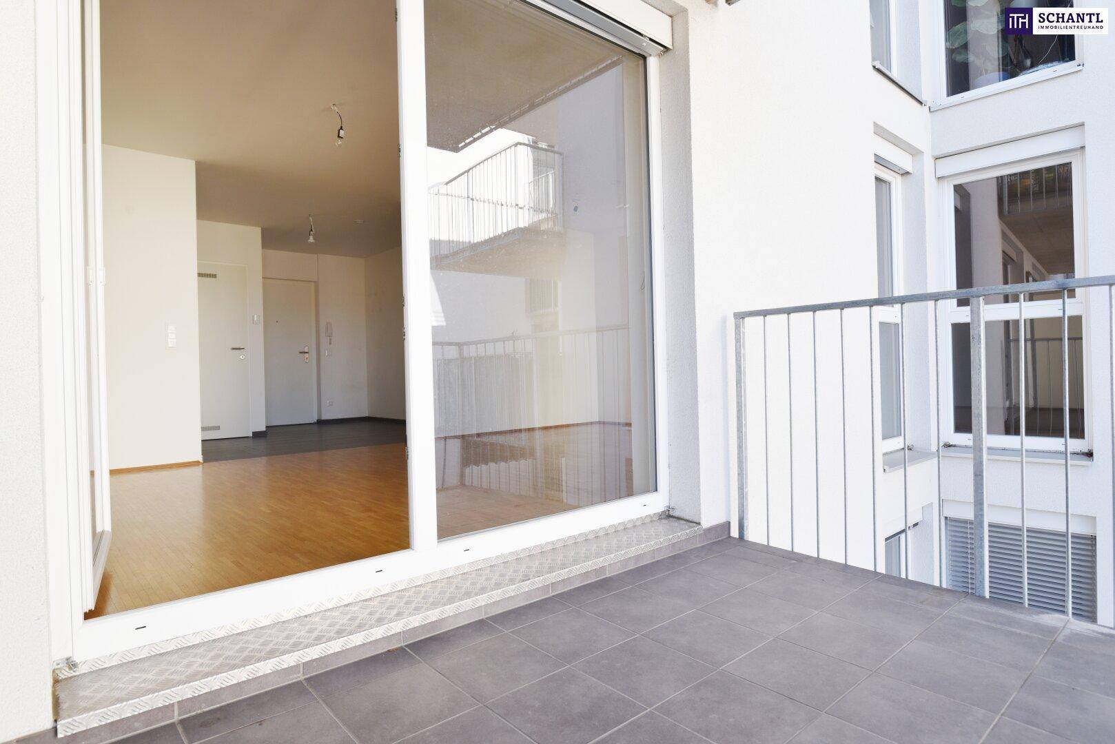 Balkon mit Fliesenboden und großer Glasschiebetür zum Innenraum.