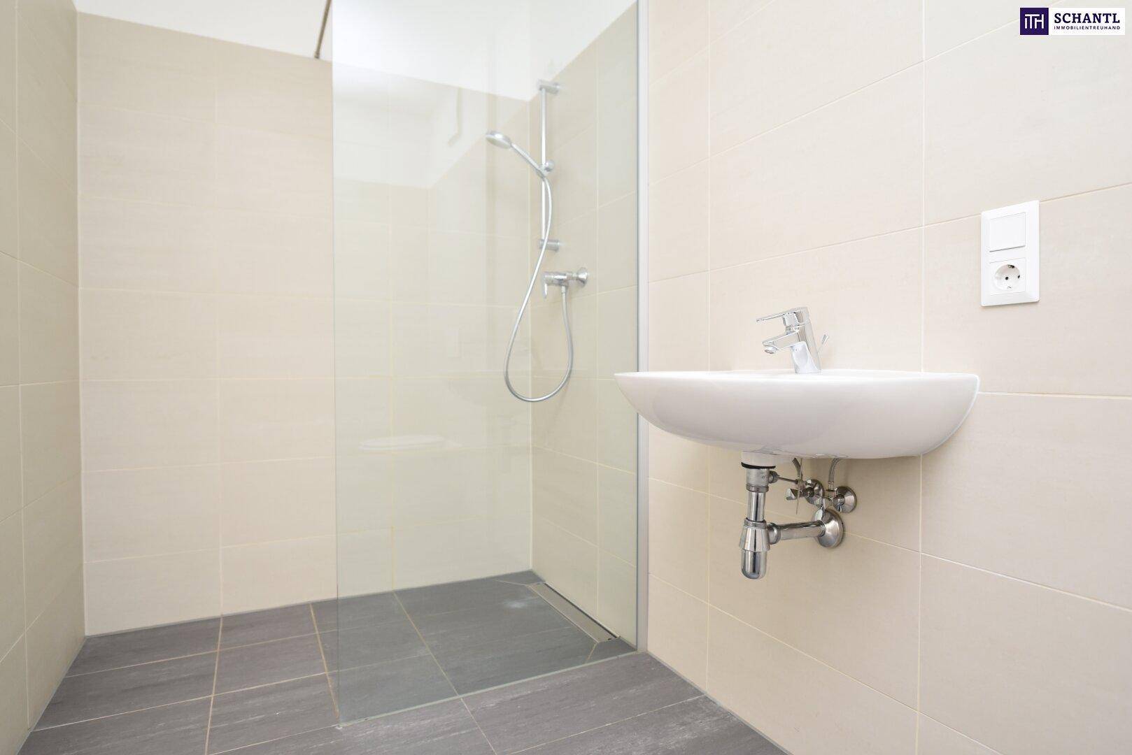 Modernes Badezimmer mit ebenerdiger Dusche, Waschbecken und hellen Fliesen.