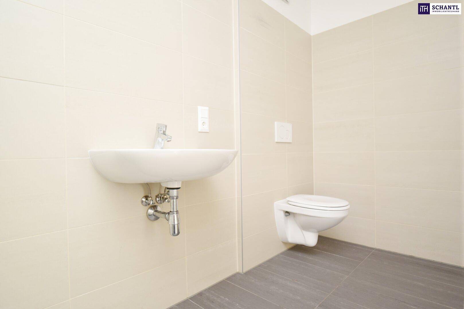 Modernes Badezimmer mit hellen Fliesen, wandhängendem WC und Waschbecken.