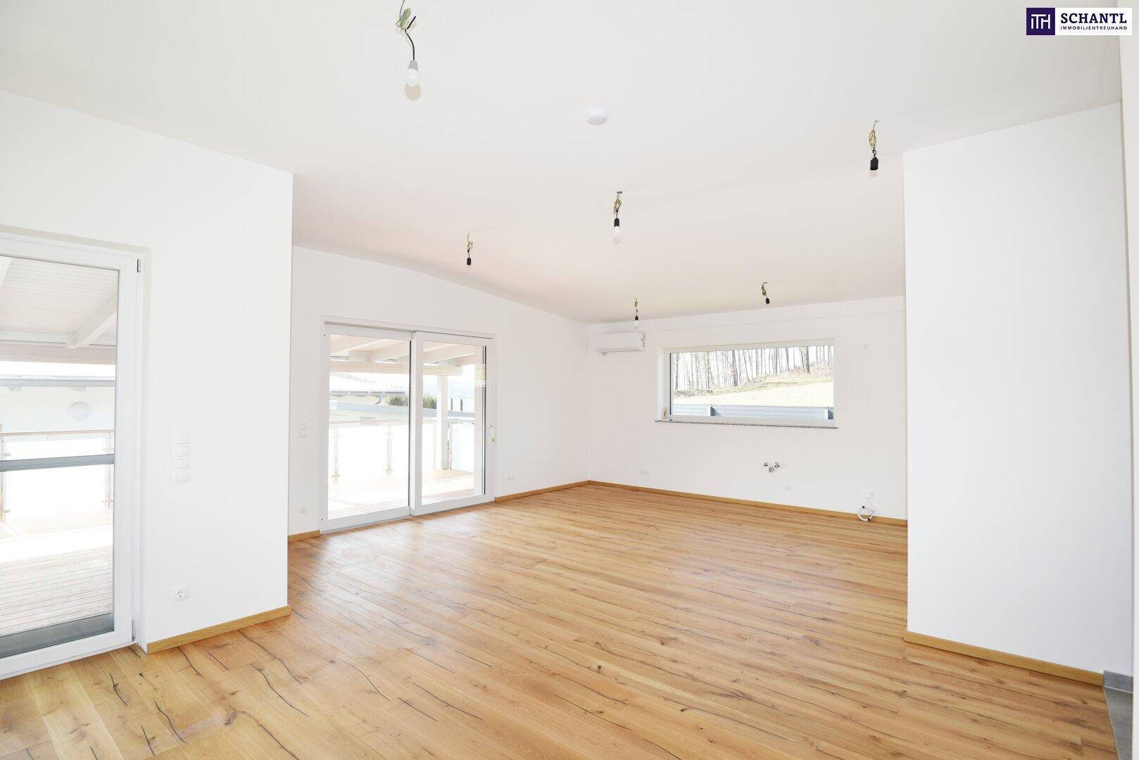 Geräumiges, helles Wohnzimmer mit Holzboden und Zugang zu einem großen Balkon.
