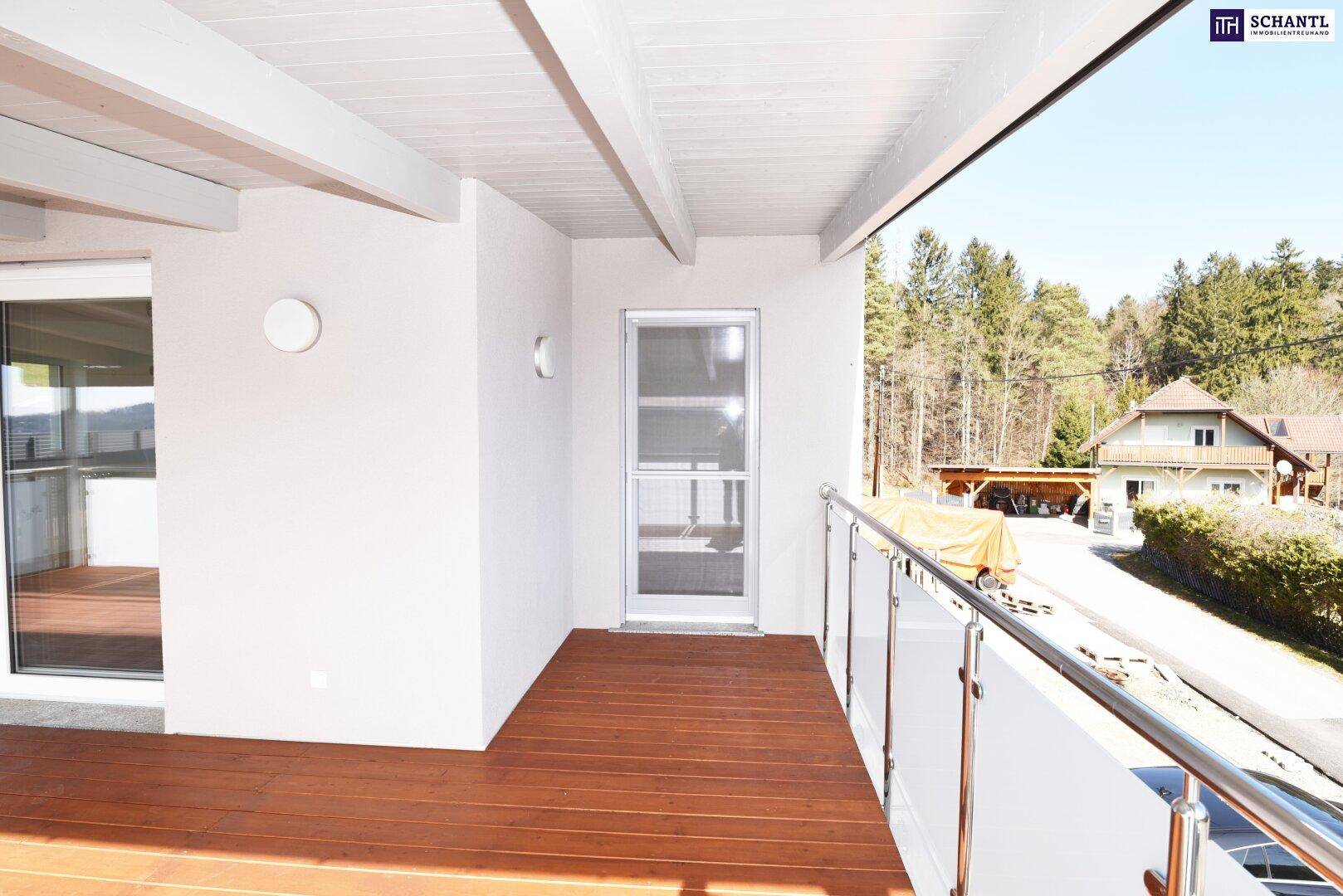 Heller überdachter Balkon mit Holzboden und Blick auf die umliegende Natur.