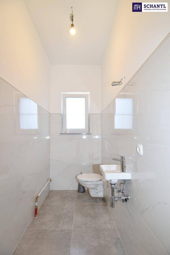 Modernes Gäste-WC mit Wand-WC, kleinem Waschbecken und Fenster für Tageslicht.