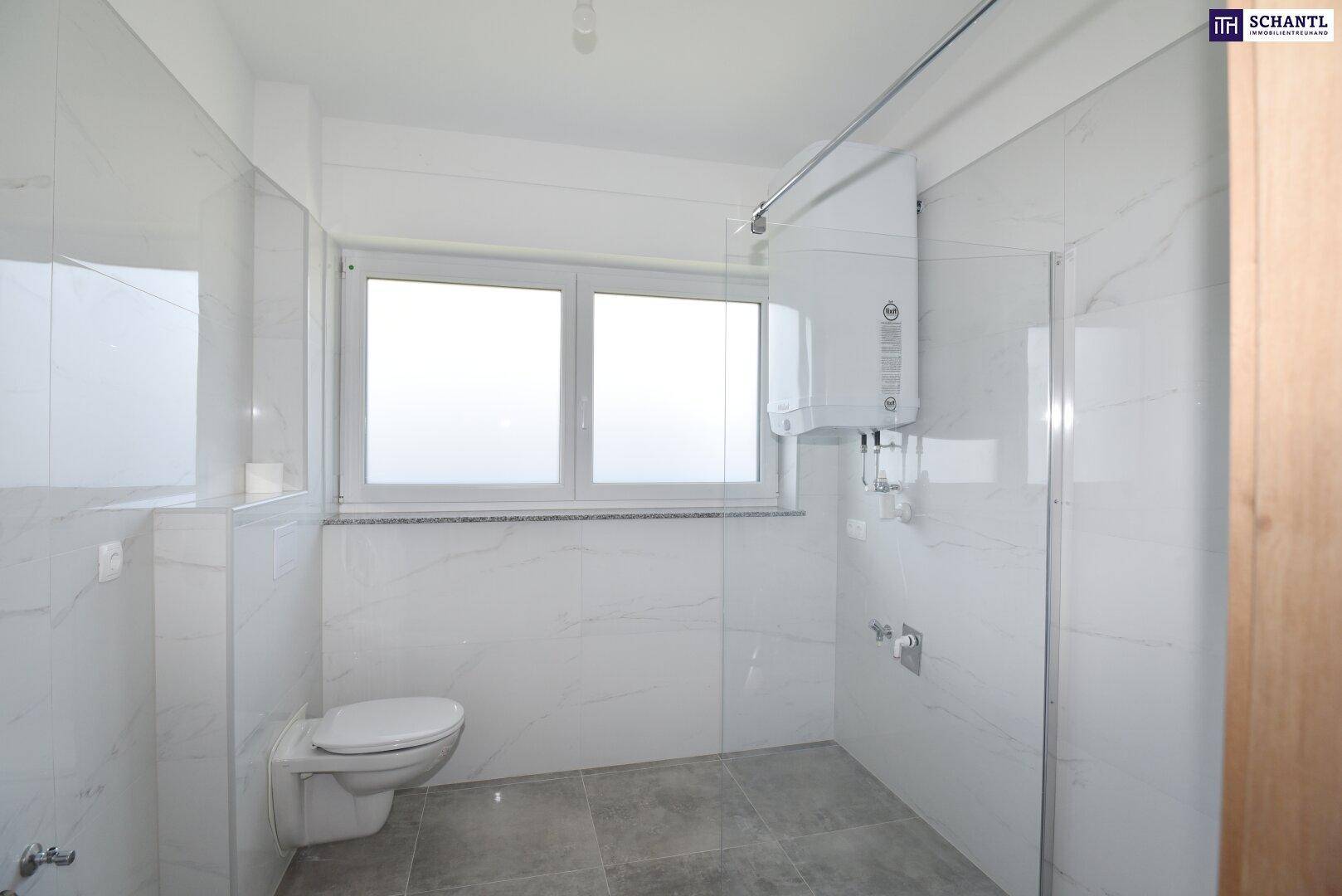 Modernes Badezimmer mit Wand-WC, Duschbereich und Fenster, hell gefliest.