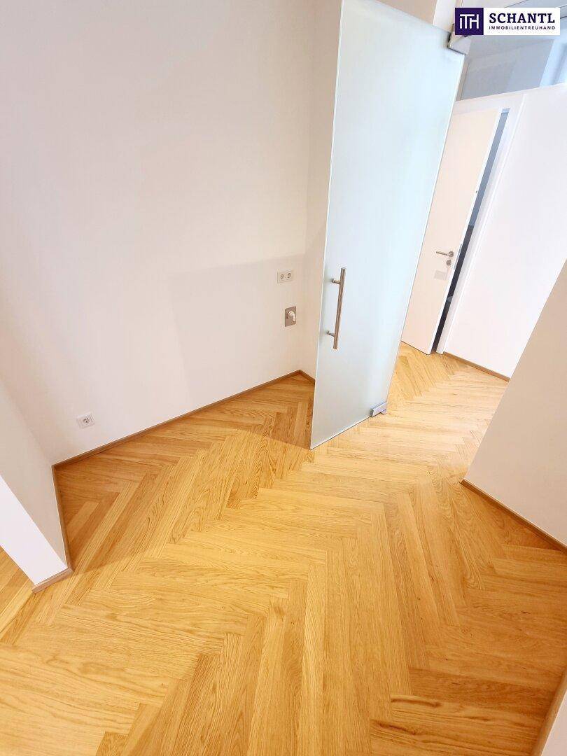Heller Flur mit Milchglastür und neuem Fischgrätparkettboden.