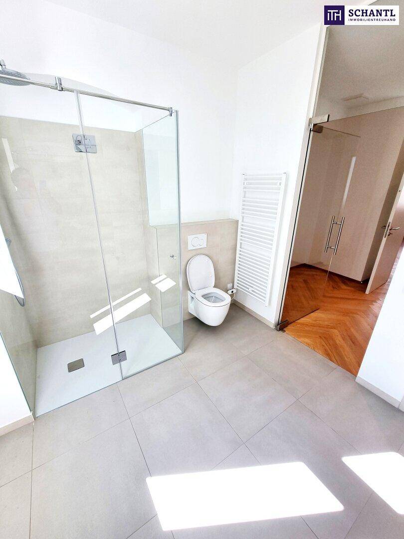 Helles Badezimmer mit ebenerdiger Dusche, Toilette und beheiztem Handtuchhalter.