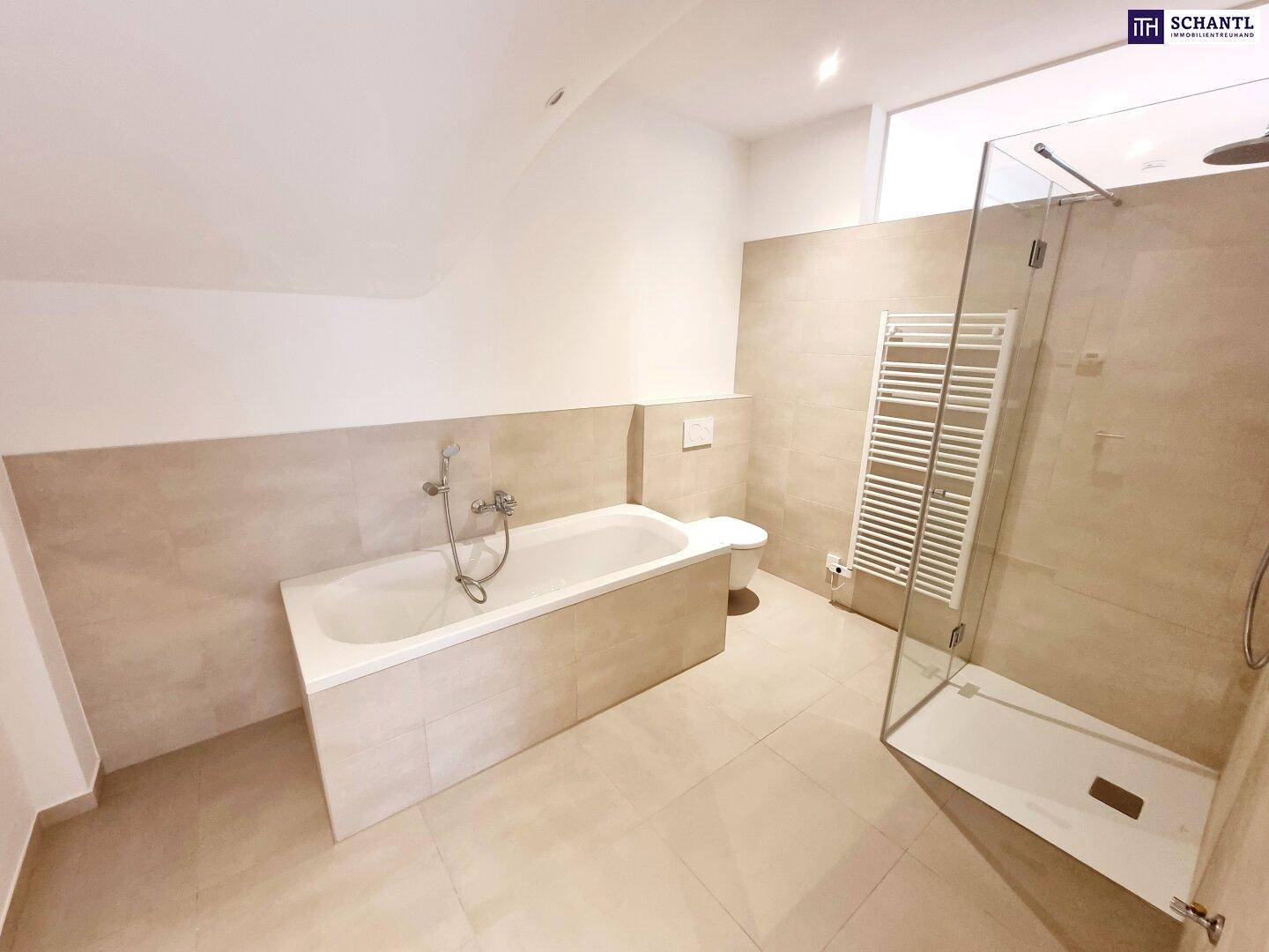 Modernes Badezimmer mit Badewanne, ebenerdiger Dusche und beheiztem Handtuchhalter.