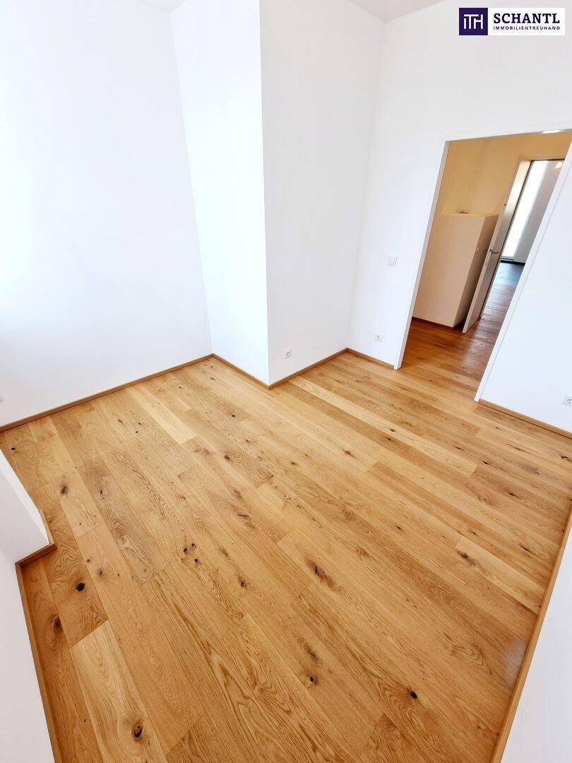Geräumiges Zimmer mit hellem Eichenparkett und weißen Wänden, ideal als Schlafzimmer.